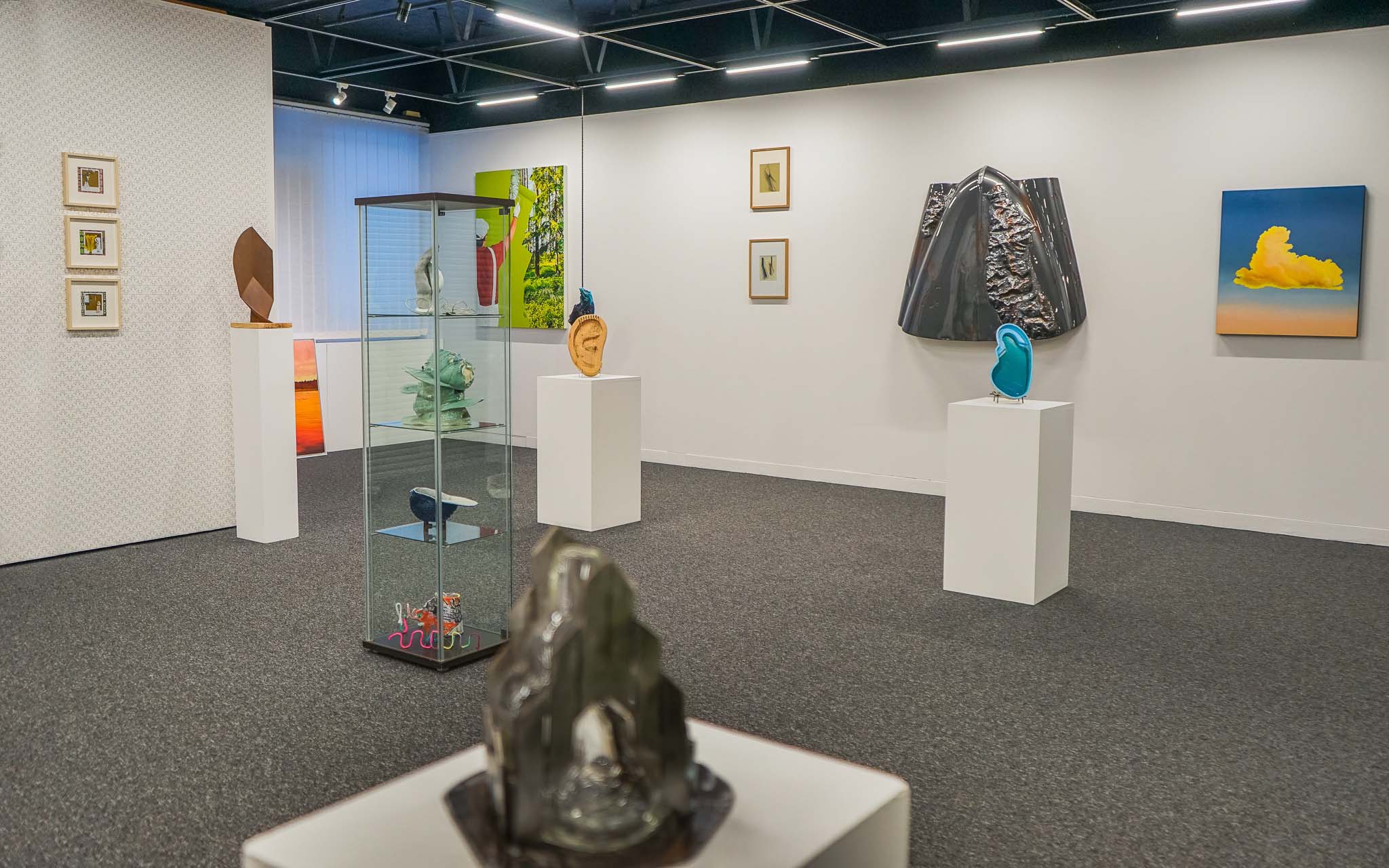 Vue de l'intérieur du Centre d'Art de Flaine, montrant différentes sculptures, œuvres d'art et peintures exposées dans l'espace.