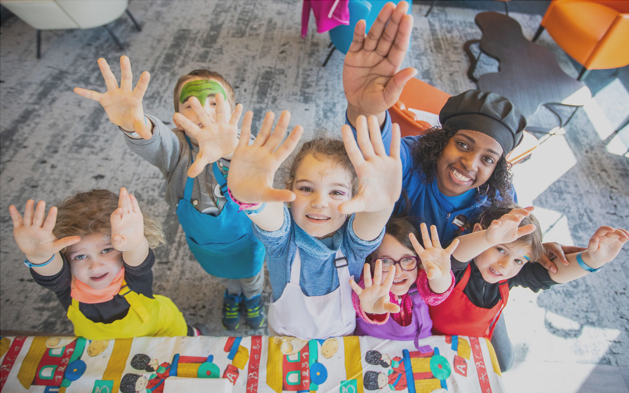 Flaine- kinderen schilderen met een kinderoppas op het terrein van de crèche.