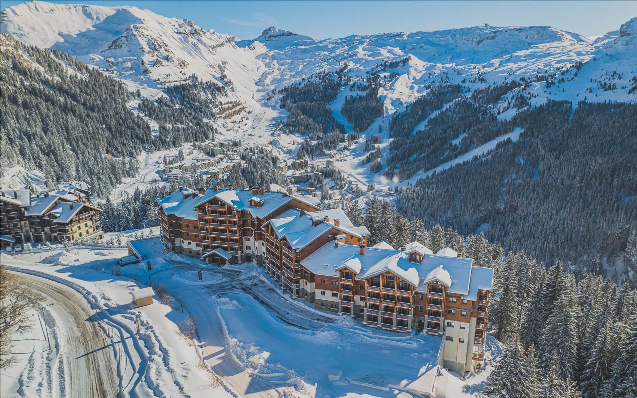 Toeristenresidentie Belambra in Flaine, besneeuwd, met het resort, het skigebied en de Désert de Platé op de achtergrond.