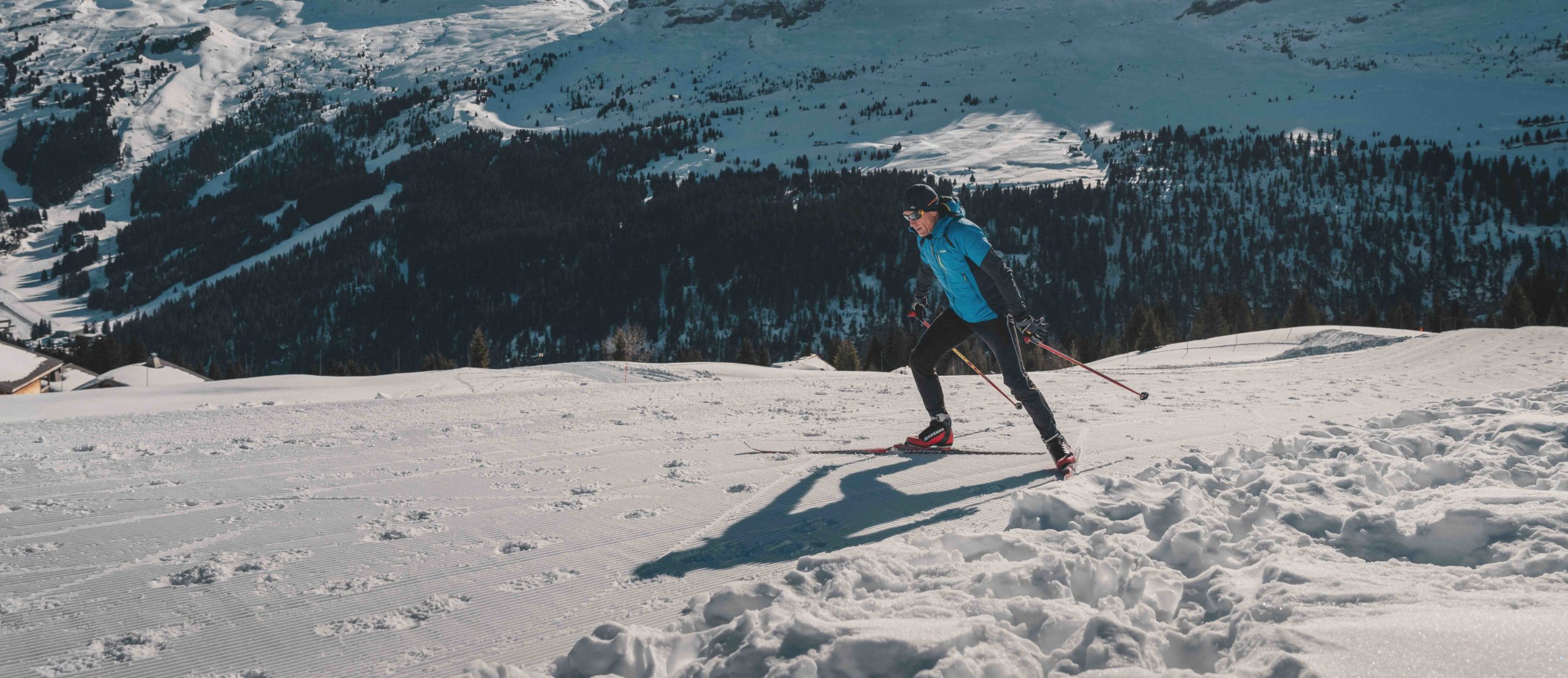 Flaine - A skier practising Nordic skating on a snow-covered groomed run, with the Flaine ski area in the background.