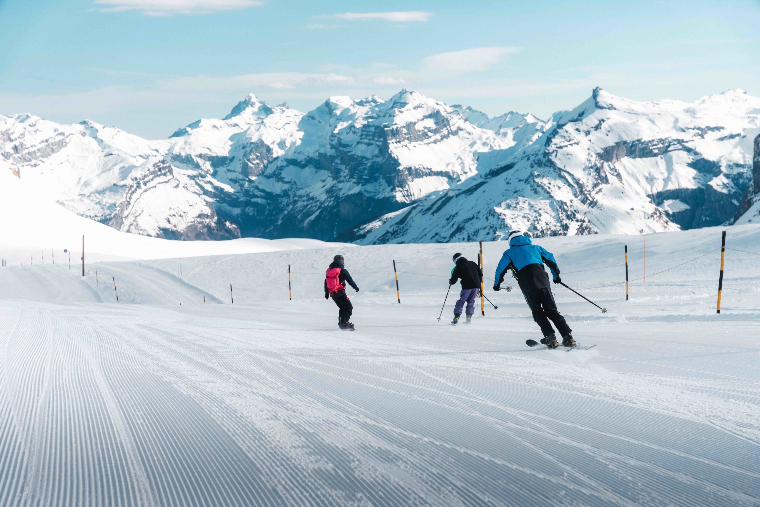 Drie skiërs skiën een helling af op de top van de Grandes Platières in Flaine