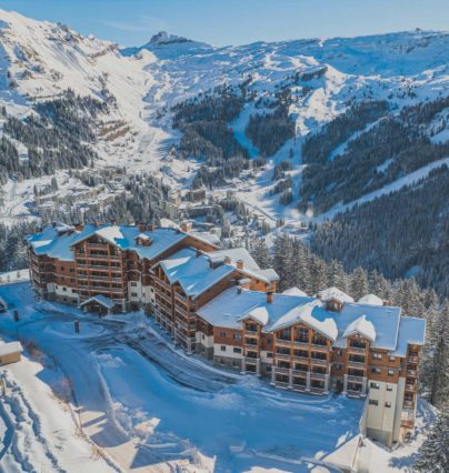 Toeristenresidentie Belambra in Flaine, besneeuwd, met het resort, het skigebied en de Désert de Platé op de achtergrond.