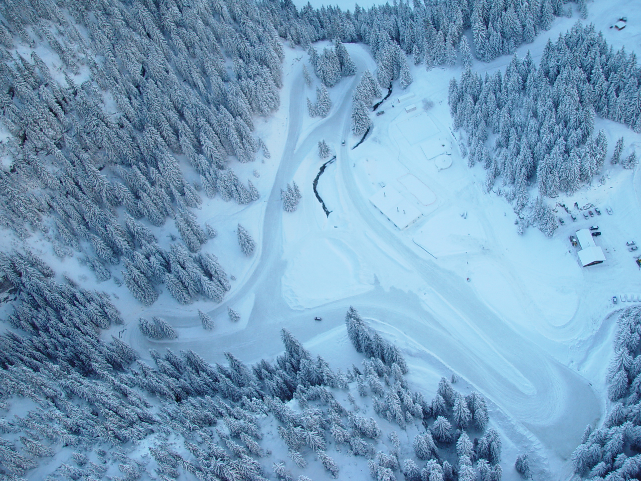 Aerial view of an ice circuit surrounded by snow-covered fir trees at the Flaine resort in the French Northern Alps, designed for off-ski activities.